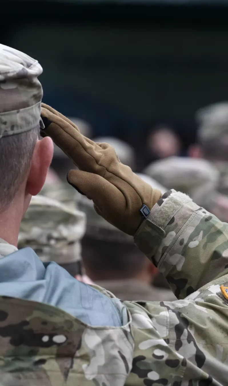 A service member salutes during a remembrance ceremony