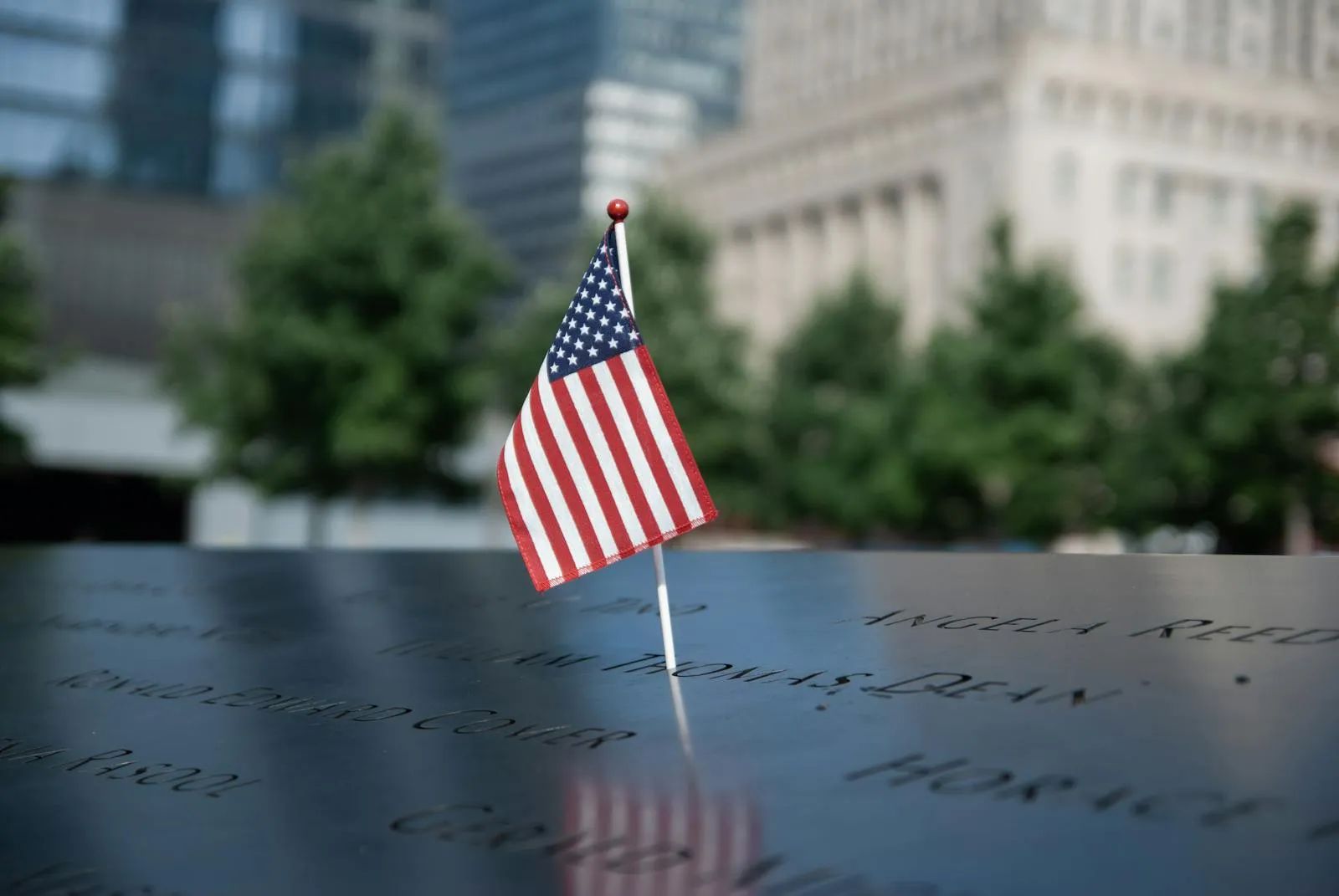 An American flag at a memorial engraved with the names of the fallen